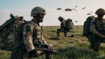 Soldiers from 3rd Battalion, The Parachute Regiment prepare to patrol off the drop zone after jumping from an RAF A400M Atlas during a Joint Airborne Task Force exercise on Salisbury Plain