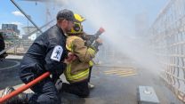 A Vietnamese youngster gets to grip with Spey's fire fighting kit pic MOD