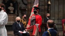 A flag bearer at Westminster Abbey in London with Boris Johnson in background, during a service to mark Armistice Day and the centenary of the burial of the Unknown Warrior (Picture: PA).