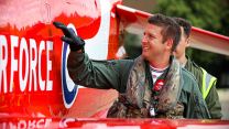 A new member of the Red Arrows next to one of the aircrafts