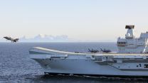 Aerial image of HMS Prince of Wales with Fjord in the background as a F35-B Lighting Jet takes off 03032024 CREDIT MOD