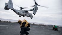 Aviation Boatswain's Mate Braces Against Rotor Wash 