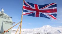 British flag flies on HMS Prince of Wales with island of Jan Mayen in the background 130422 CREDIT Royal Navy