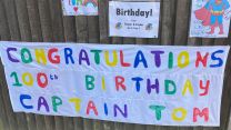 Children and adults have been celebrating Captain Tom Moore's birthday in his village displaying signs and cards.