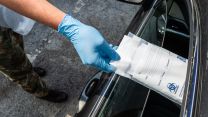 Coronavirus test kit is posted through the car window at the Mobile Testing Unit in Kenda