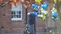 Captain Sir Tom with '100' balloons outside his Bedfordshire home (Picture: PA).