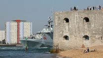 Families watch HMS TAMAR as she leaves HMNB Portsmouth and passes the Round Tower to be forward deployed in the Indo-Pacific Region