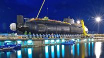 HMS Artful, the Royal Navy's third Astute Class nuclear submarine, being lowered into the water at Barrow-in-Furness, Cumbria