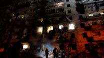 Ukrainian firefighters respond to the a rocket attack on a residential building attacked by Russian military forces