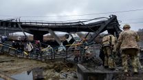 Ukrainian troops help civilians cross the shelled bridge connecting the town of Irpin and Kiev