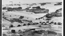Landing craft, barrage balloons and allied troops assault a Normandy beach