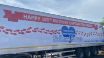 A large truck in Captain Tom Moore's village displays a birthday wishes message.