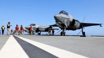 Members of VFMA-211 prepare an F35B Lightning Jet for a launch from HMS Queen Elizabeth