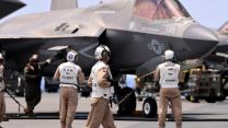 Members of VFMA-211 prepare an F35B Lightning Jet for a launch from HMS Queen Elizabeth as the Carrier Strike Group joins the fight against