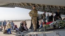 Afghans board an RAF aircraft at Kabul airport