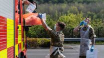Patient drops off completed self test CORONAVIURS COVID19 kit into the collection box during the Mobile Testing Unit at Scarborough