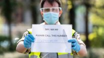 Soldier from 1st Battalion Duke of Lancaster Regiment holds phone number to vehicle driver at COVID19 Coronavirus mobile testing unit in Kendal 