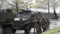 Soldiers alongside Foxhound vehicle during a demonstration.