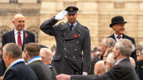 The Secretary of State for Defence, John Healey and the Prince of Wales on the podium, taking the salute from veterans as they march past Horse Guards Parade at the the National Service of Remembrance
