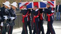 The coffin of Major General Matthew Holmes, former head of Royal Marines, is carried into Winchester Cathedral in Hampshire