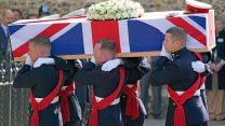 The coffin of Major General Matthew Holmes, former head of Royal Marines, is carried into Winchester Cathedral in Hampshire