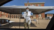 Troops from The Grenadier Guards held up cards to explain how to complete COVID19 Coroanvirus testing in Dulwich