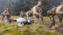 US Army Reserve Officers' Training Corps (ROTC) soldiers patrol past a Lockheed Martin Indago 4 Tactical Quadcopter during Exercise Cambian Patrol 111024 CREDIT MOD