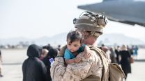 US Marine carries an infant