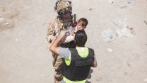 US service member carries a child during an evacuation at Kabul airport 
