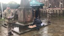 A young girl pays her respects on Armistice Day at 3 Rifles memorial garden, Redford Barracks Edinburgh.