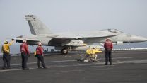 'Yellow shirts' guide the jets into position on the deck, while 'red shirts' handle fuel and ammunition