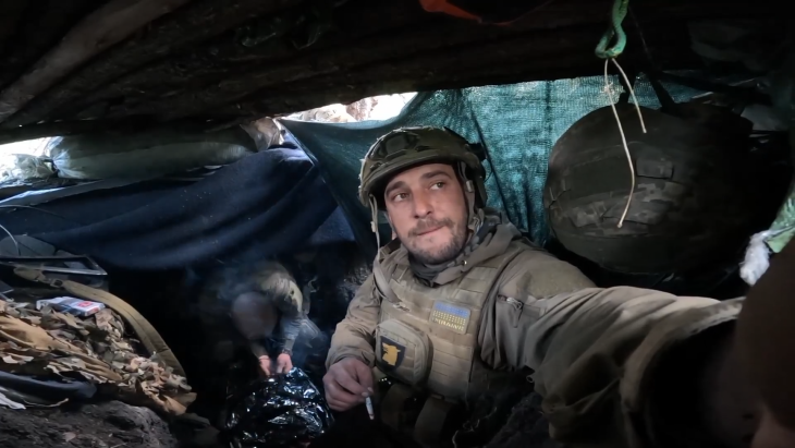 Ukrainian soldier in a trench smoking