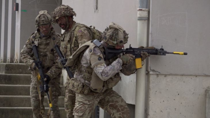 1 Lancs infanteers use the cover of a street corner as they work their way forward, building by building