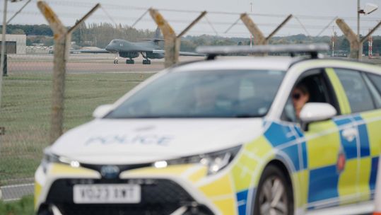 Police patrol the perimeter as a US Air Force Rockwell B-1 Lancer bomber lands at RAF Fairford in Gloucestershire (Picture: PA Images)