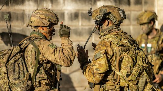 A British Gurkha and an Australian soldier discuss something