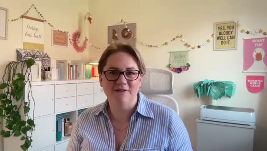 Jess Sands in a cosy room with inspirational posters in the background
