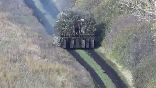 The vehicles are heavily protected by an anti-drone lattice of rods, which give them a dandelion appearance (Picture: YouTube Code 9.2)