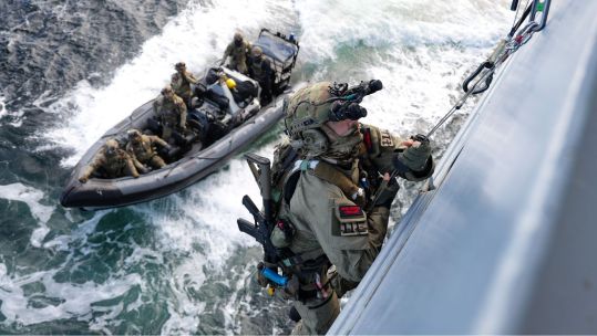 Royal Marine from K Company, Royal Navy, uses a caving ladder to gain entry onto a vessel (Picture: MOD)
