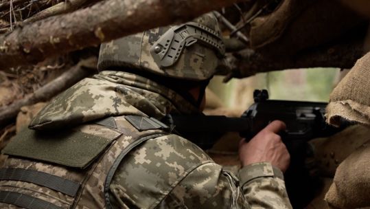 A Ukrainian soldier keeps a lookout for the enemy while being trained on Operation Interflex