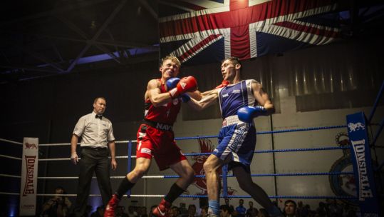 SAC (Senior aircraftman) Arran Devine (right), delivers a powerful uppercut on his Royal Marine opponent (left). Crown Copyright