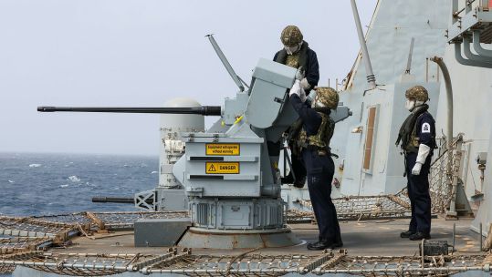 Personnel wearing protective clothing operate one of the 30mm Small Calibre Guns during live firing gunnery serials on board HMS Dragon - the crew also tested the Phalanx close-in weapon systems (Picture: MOD)