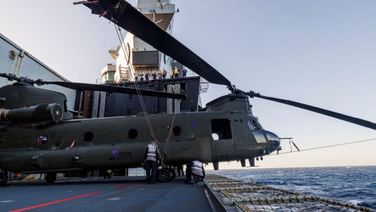 A Chinook helicopter – here ZH777 – just about fits on the aircraft lift, its nose protruding over the edge (Picture: MOD)