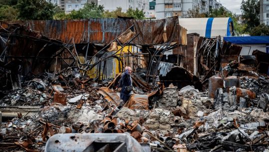 A local resident walks by a street market destroyed by military strikes in Saltivka, one of the most damaged residential areas of Kharkiv, Ukraine