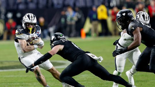 2YXA38T Navy's Eli Heidenreich slides away from Army's Max DiDomenico during a NCAA football game between the United States Naval Academy and the United States Military Academy 151224 CREDIT Alamy