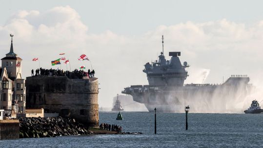 Crowds wave from the Round Tower as HMS Prince of Wales sails towards Portsmouth Naval Base