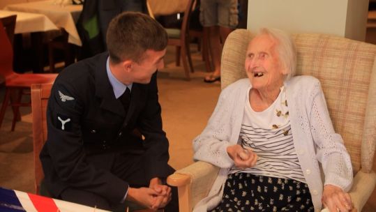 99 year old RAF veteran Peggy Terry is presented with a set of five shilling coins.
