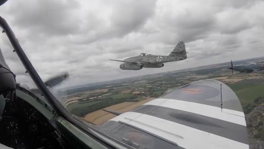 A Spitfire from the Battle of Britain Memorial Flight flying alongside German WWII-era aircraft