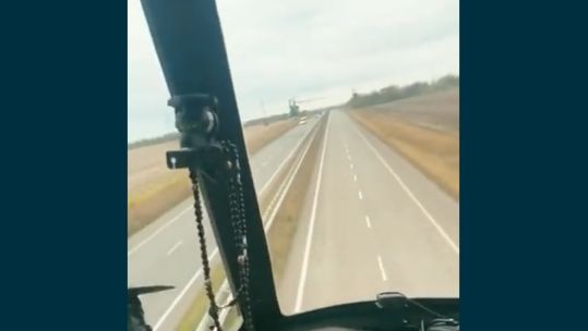 A Ukrainian Hind attack helicopter flying along the country's highways