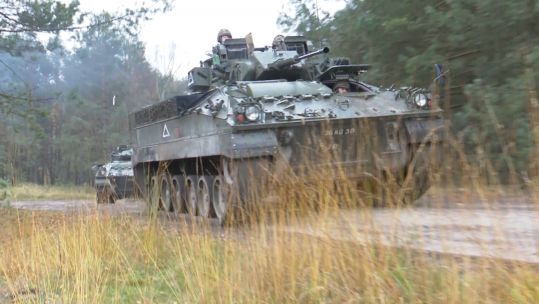A Warrior Infantry Fighting Vehicle seen through the grass as Mercian personnel train on Sennelager Training Area in Germany.