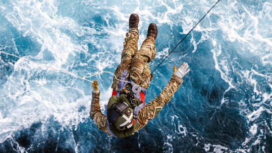 A crewman from 845 Squadron is carefully lowered from the Merlin Mk4